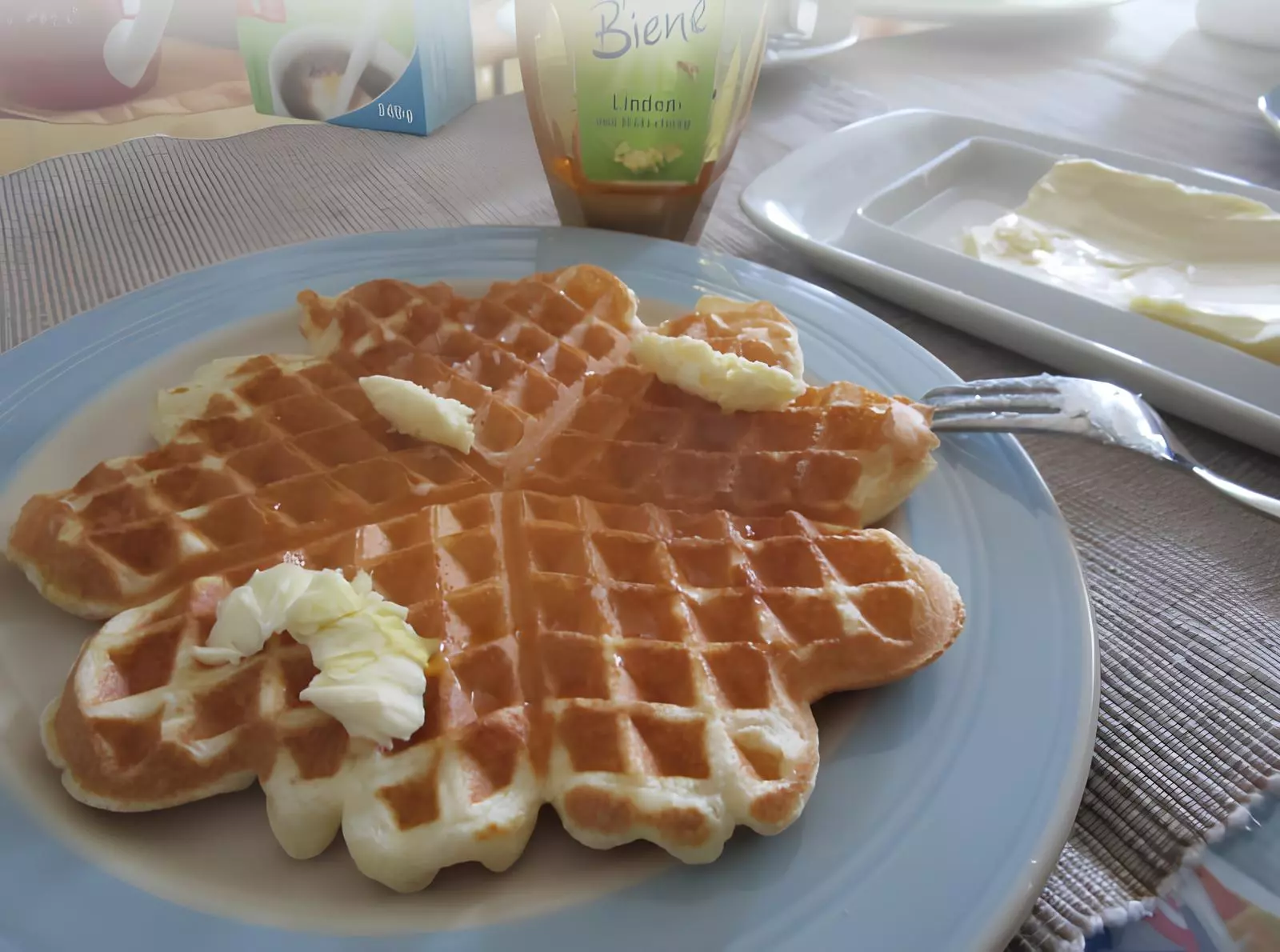 um prato com waffle da vovó em cima de uma mesa preparada para café.