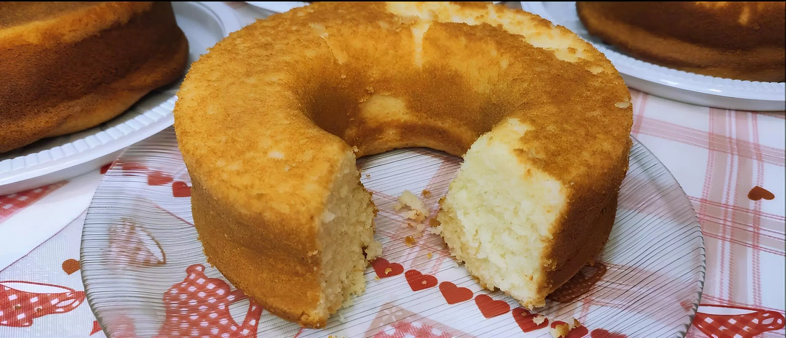 um bolo de polvilho da vovó em cima de uma mesa preparada para café da tarde.