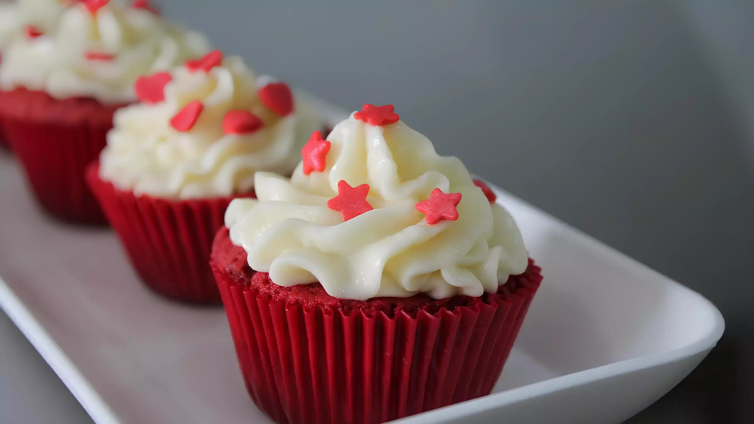 três cupcakes red velvet em uma tigela prontos para serem servidos.