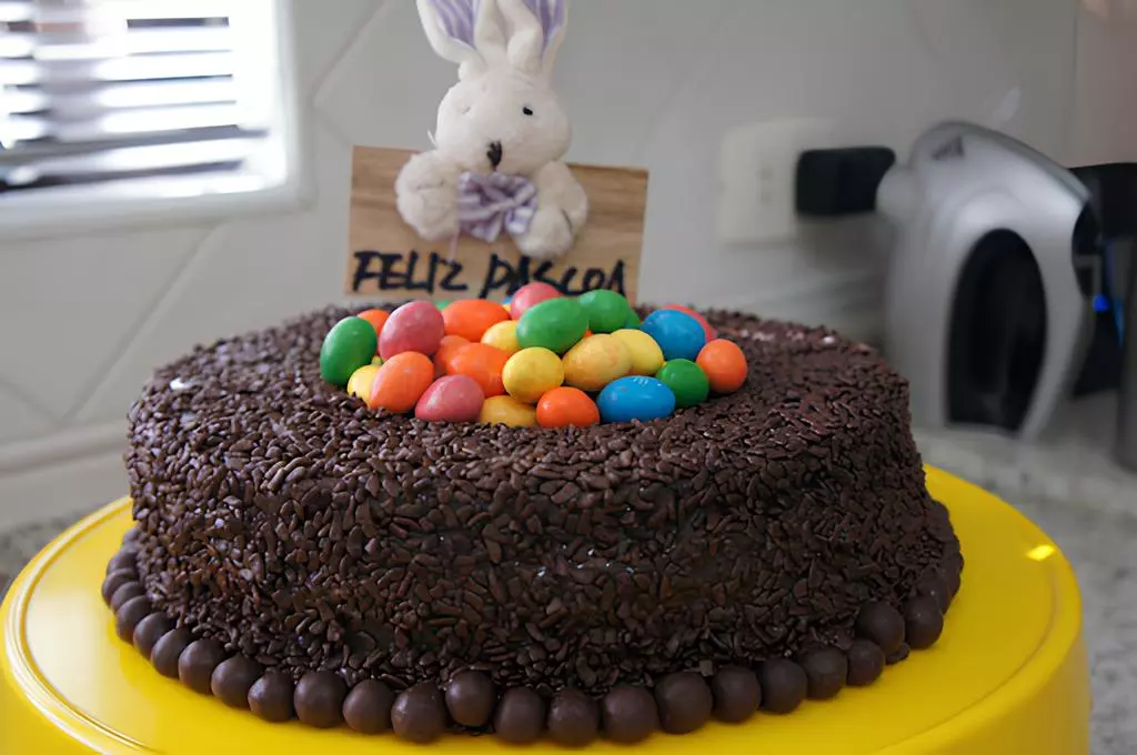 um bolo de páscoa de chocolate com enfeite de páscoa em cima dele.