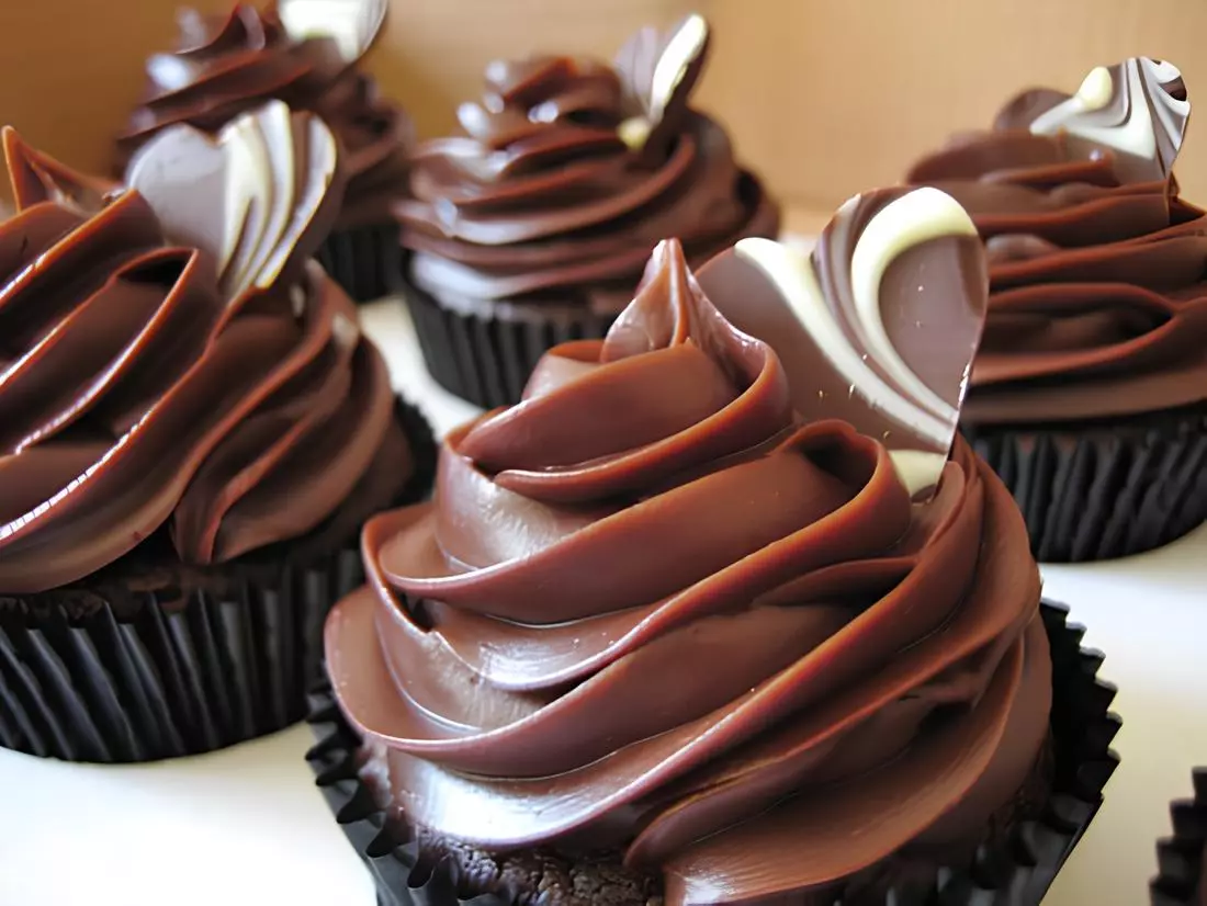 Um cupcake com cobertura e recheio de chocolate.