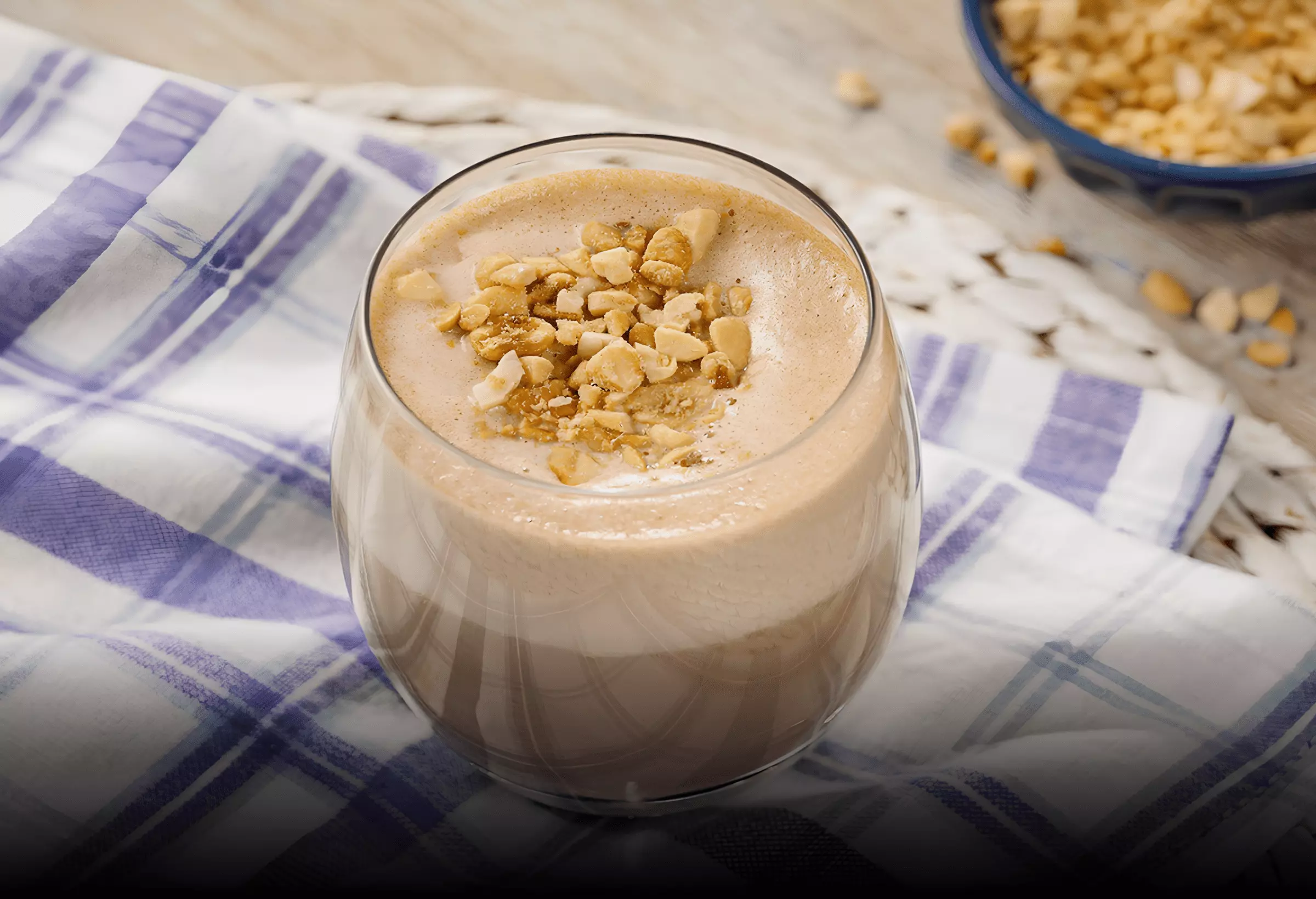 uma taça com um Smoothie de manteiga de amendoim e cacau low carb em uma mesa pronto para servir.