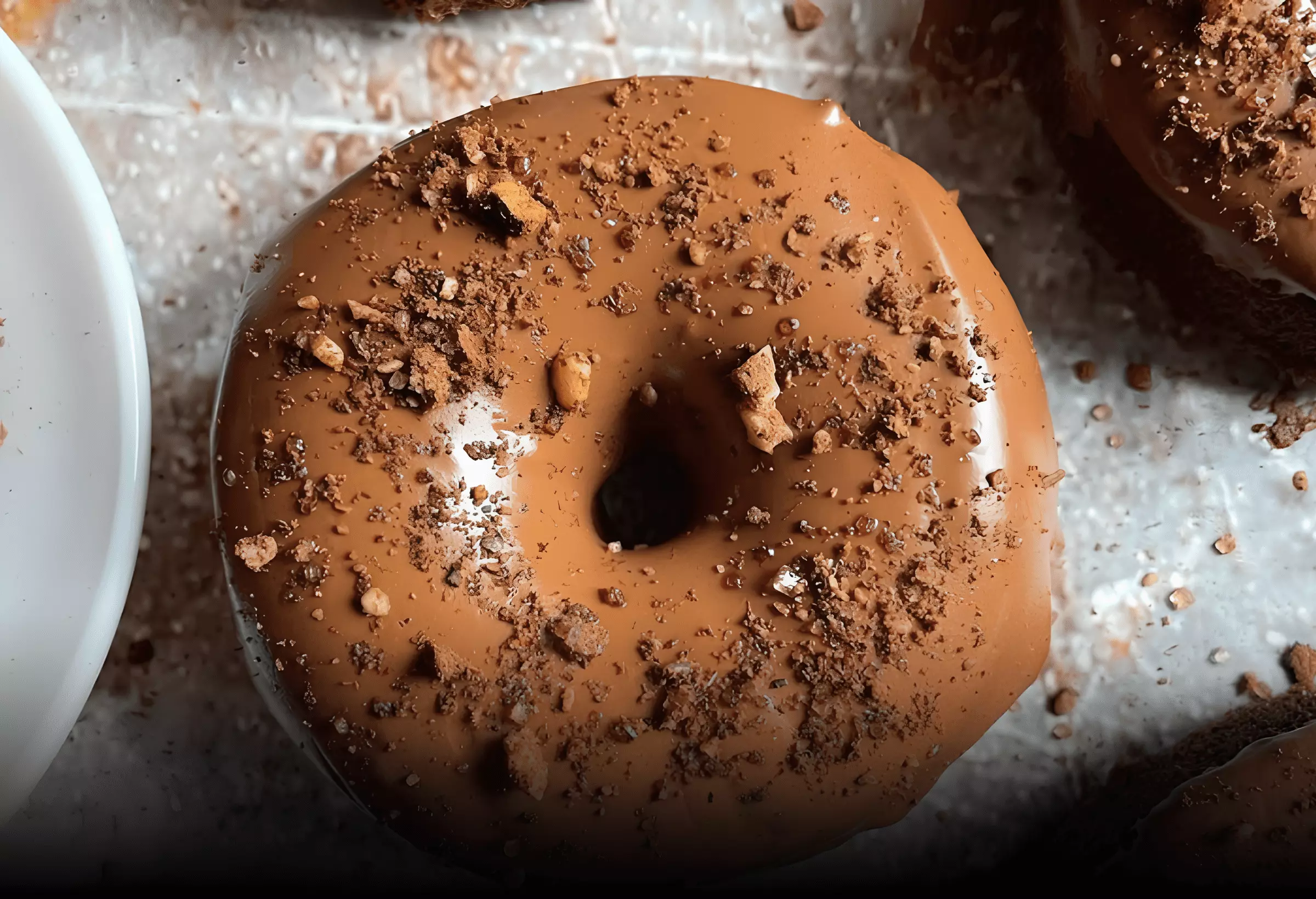 um Donuts de amêndoa low carb com cobertura de chocolate em cima de uma mesa.