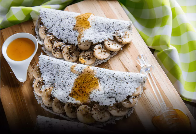 duas Tapioca low carb de chia com recheio doce de banana em cima de uma mesa decorada.