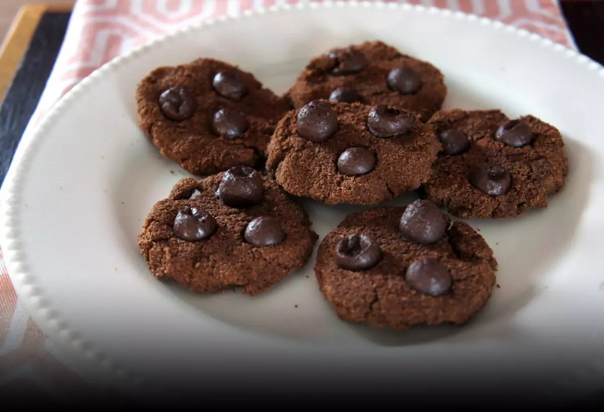 um prato com vários Cookies de chocolate low carb com pedaços de chocolate prontos para serem servidos.