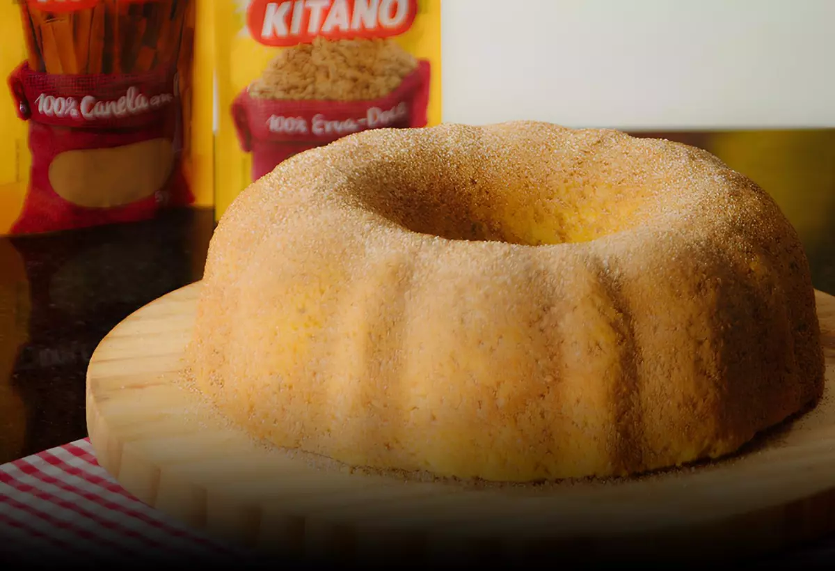 Um bolo de fubá com canela em cima de uma mesa.