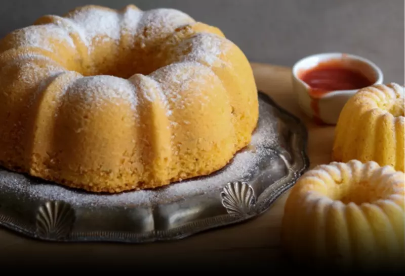 um bolo de fubá sem glúten grande e dois pequenos em cima de uma mesa decorada.