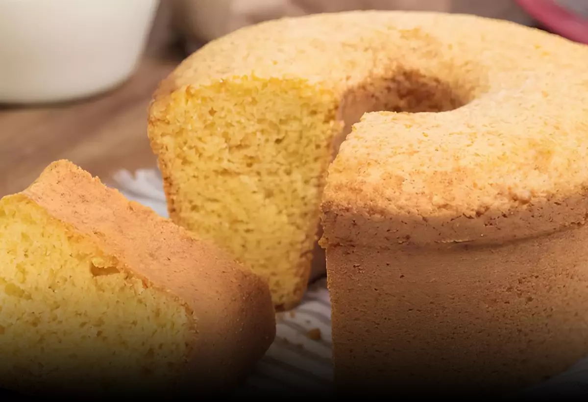 um bolo de fubá caseiro em um prato em cima de uma mesa.