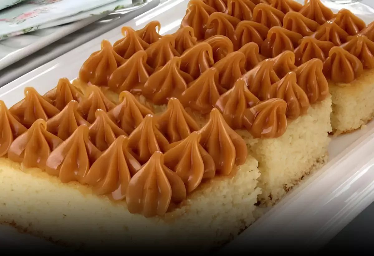 Um bolo de fuba com doce de leite em cima de uma mesa prontos para serem servidos.