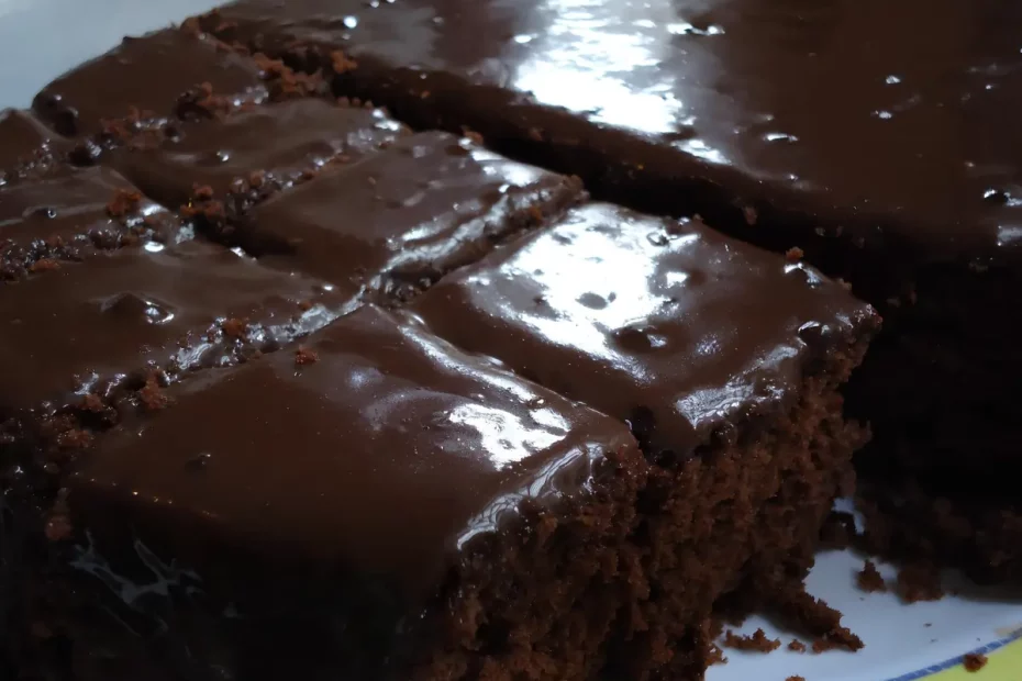 um prato com bolo nega maluca com café cortada em pedaços.