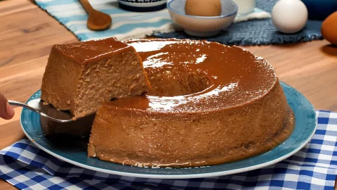 Um prato com um pudim de café com leite condensado em uma mesa decorada.