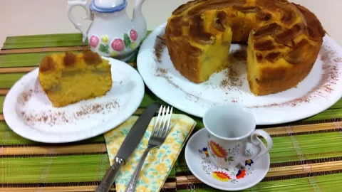 Um mesa preparada de café da manha com bolo de bana e flocão de milho.