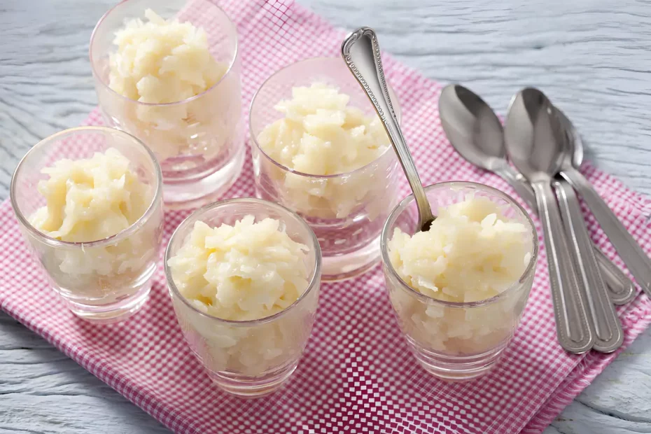 Copos com cocada cremosa em cima de uma mesa.