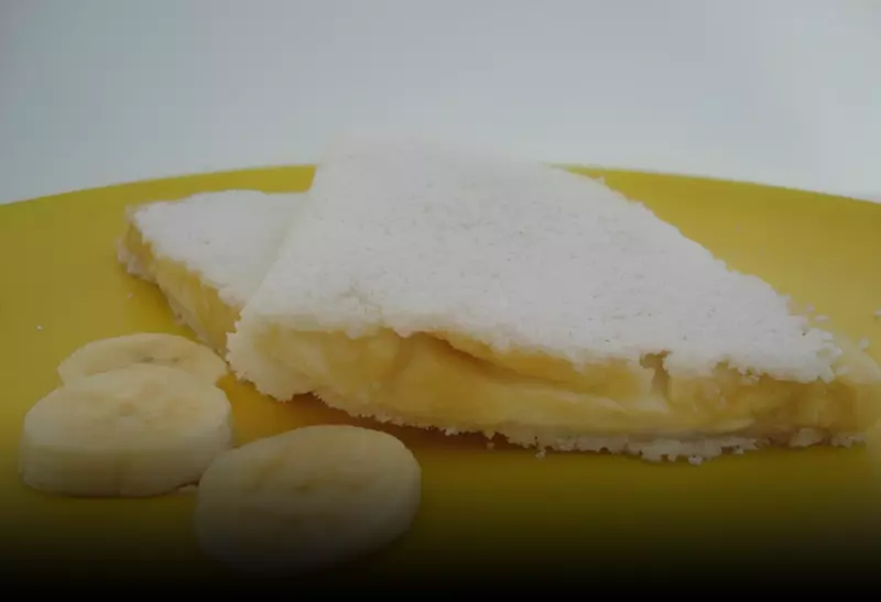 um prato na cor amarela com tapioca banana e queijo