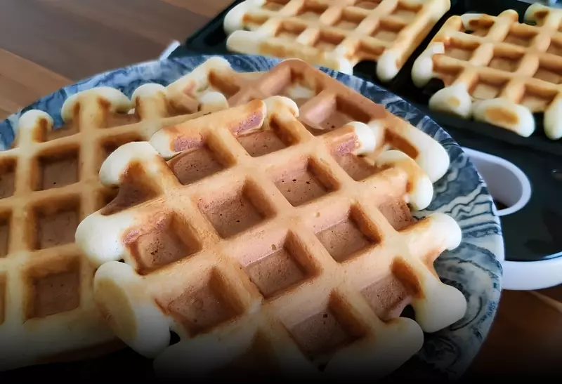 vários Waffles de coco low carb com chantilly de baunilha prontos para serem servidos.