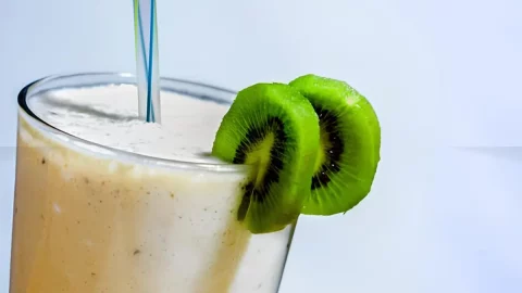 Um copo com uma vitamina de kiwi feita sem liquidificador.