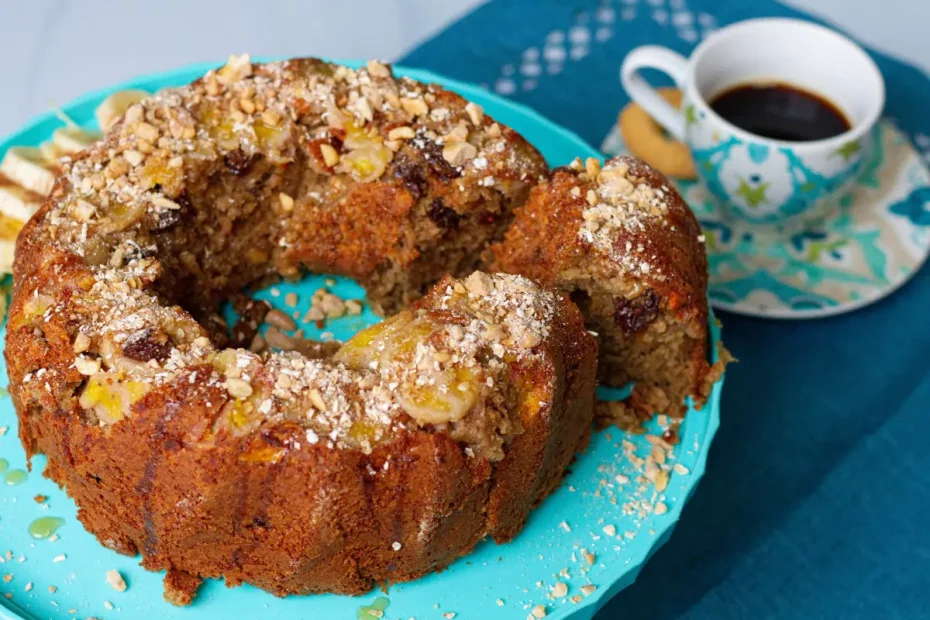 Um bolo de banana com flocos de aveia em uma mesa preparada com café.