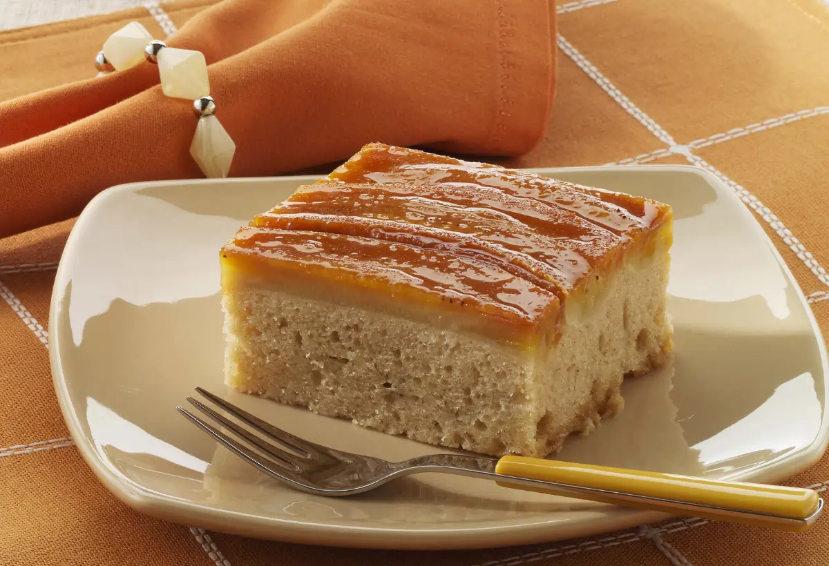 Um bolo de banana em um prato em cima de uma mesa preparada para café.