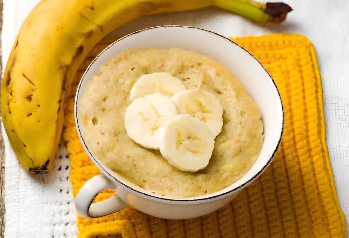 Um recheio de banana para bolos em uma caneca.