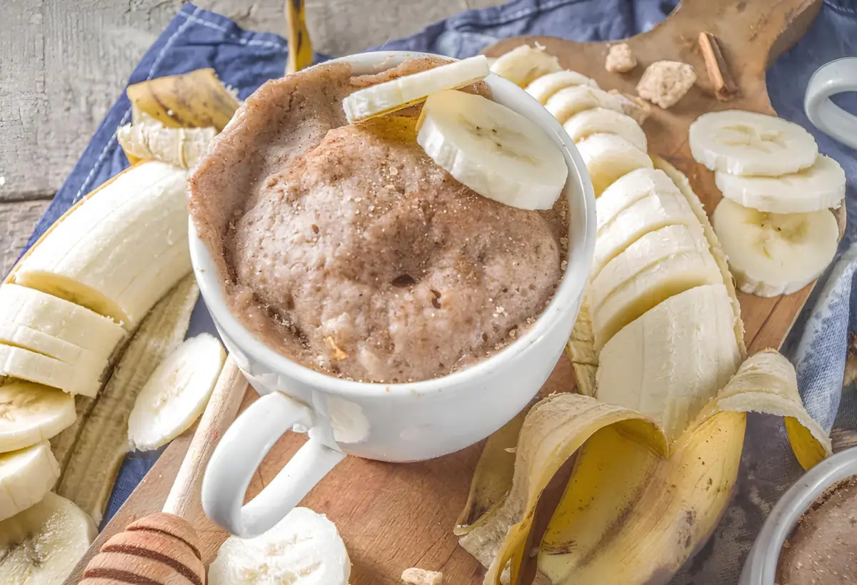 Um caneca com um bolo de banana fit de microondas