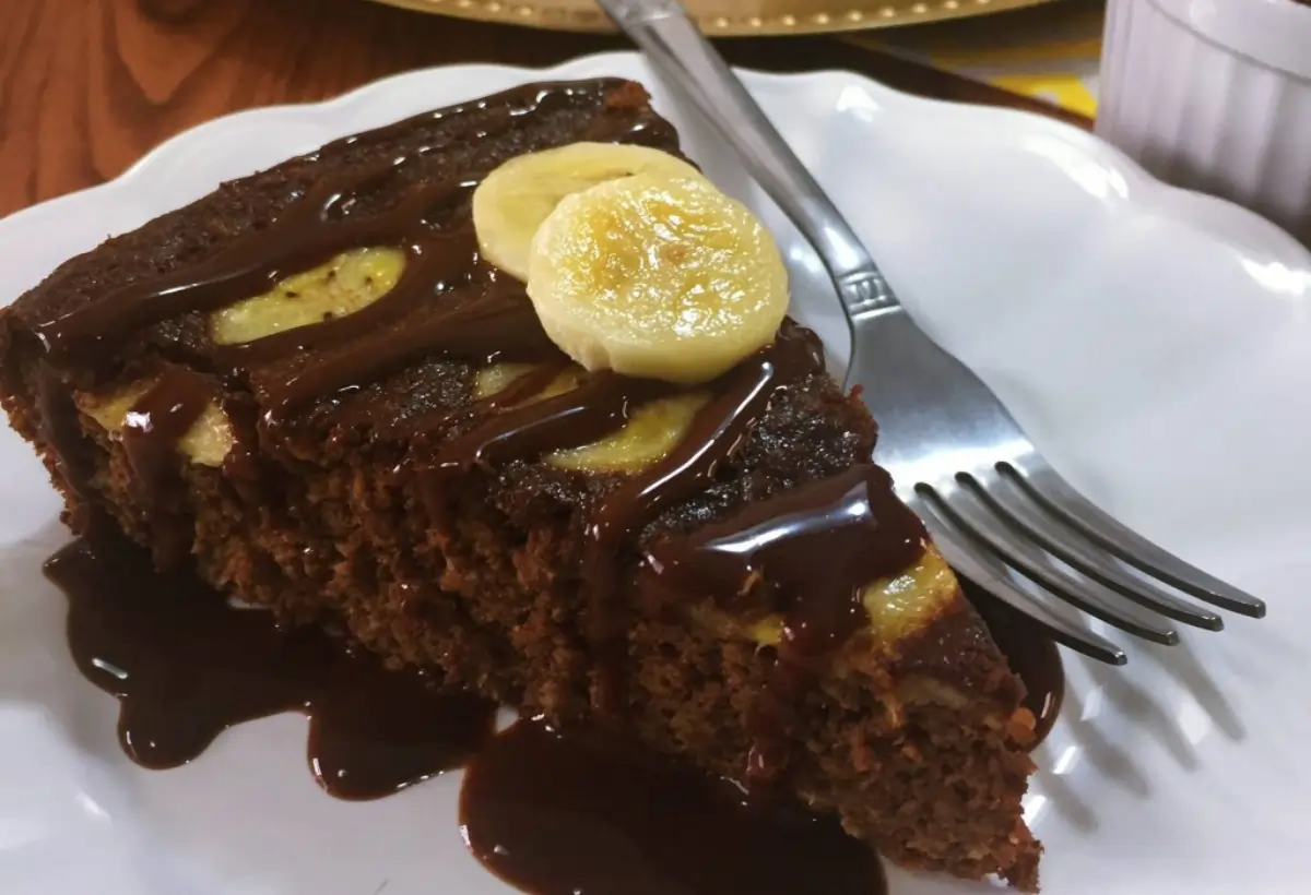 Um prato com um pedaço de bolo de chocolate com banana.