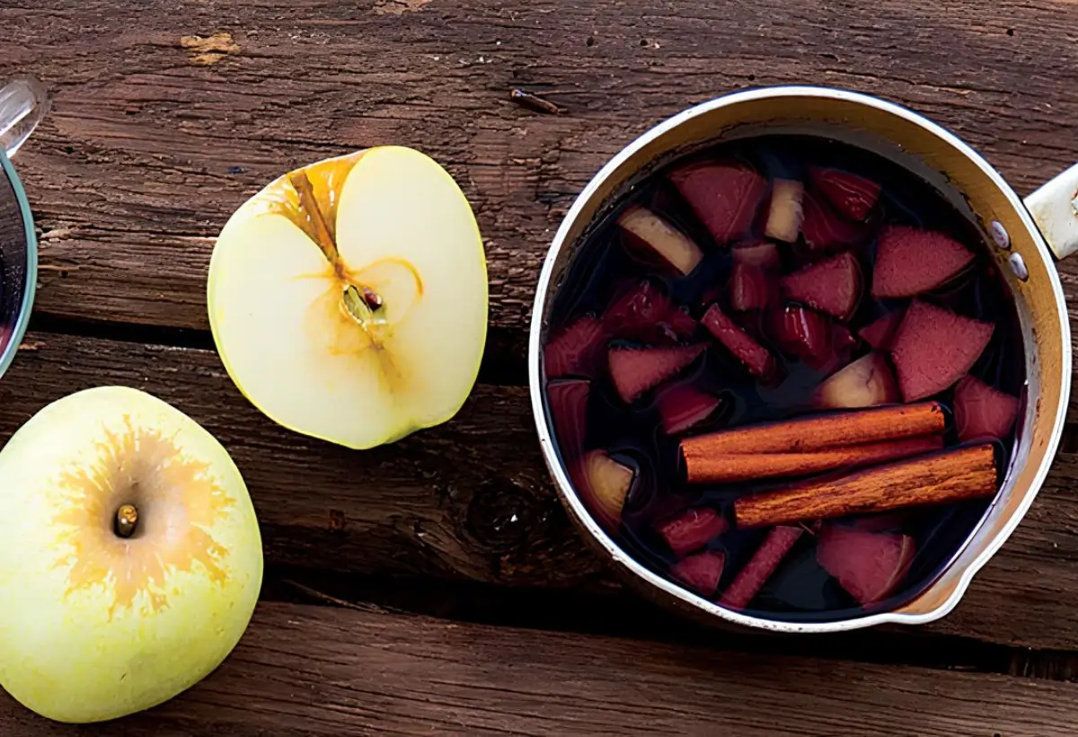 uma panela com vinho quente com maçã