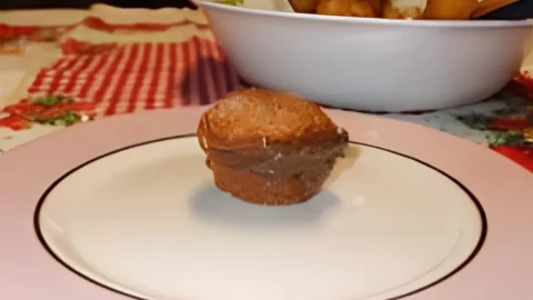 Um prato com bolinho de chuva recheado com chocolate.