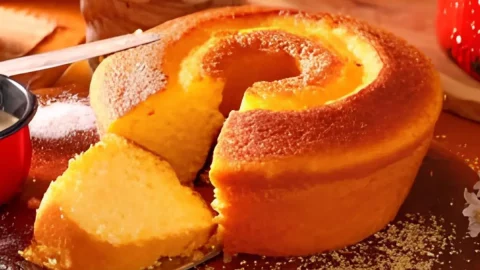 Uma mesa preparada com um bolo de fubá simples.