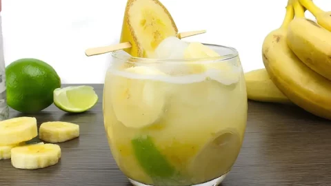 Um copo de cachaça de banana com limão.