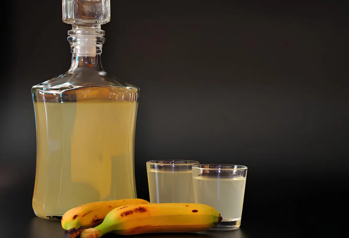 Uma garrafa e dois copos de cachaça de banana.