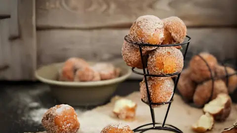 Uma mesa preparada para café com bolinhos de chuva sem glúten.