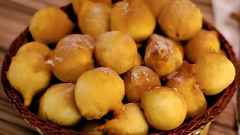 Cestinho com bolinhos de chuva tradicional em cima de uma mesa.