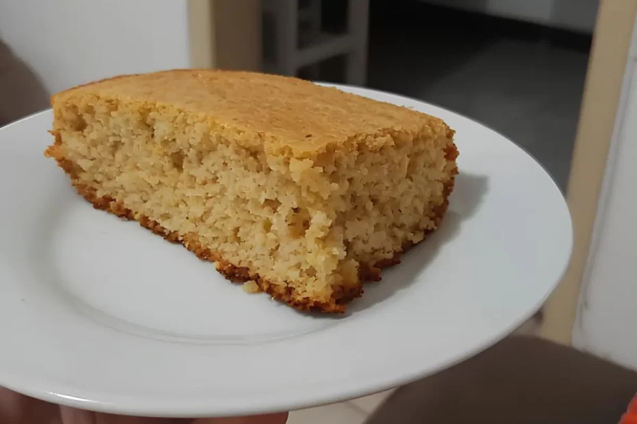 Um prato com uma fatia de bolo de fubá com aveia.