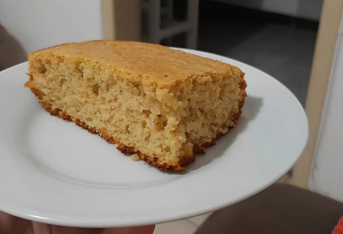 Um prato com uma fatia de bolo de fubá com aveia.