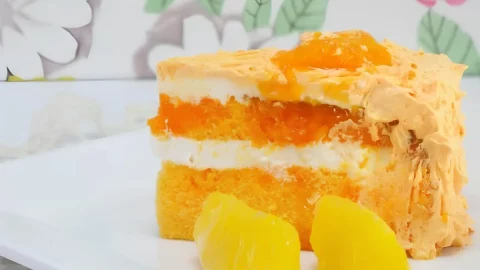 Um bolo de laranja com cobertura e recheio.