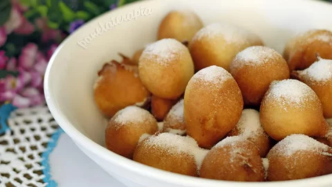 Uma tigela com bolinhos de chuva com creme de leite.