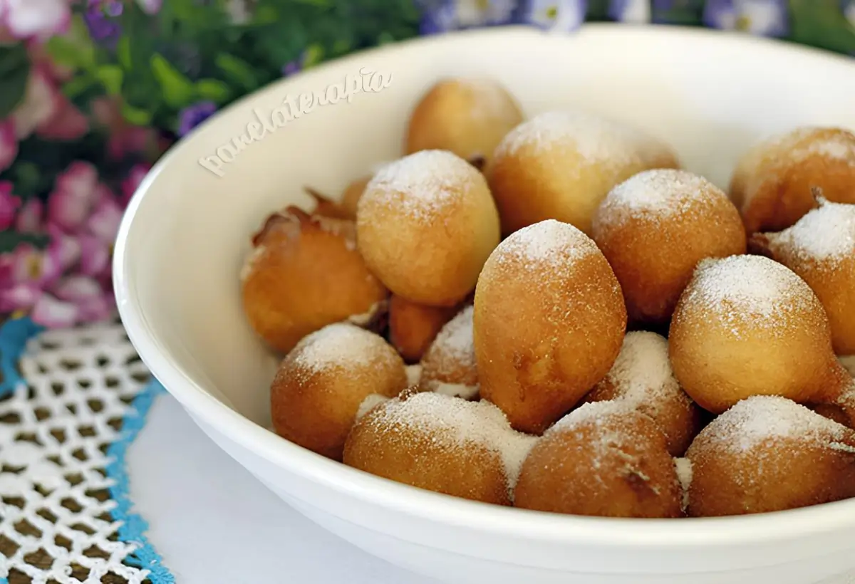 Uma tigela com bolinhos de chuva com creme de leite.