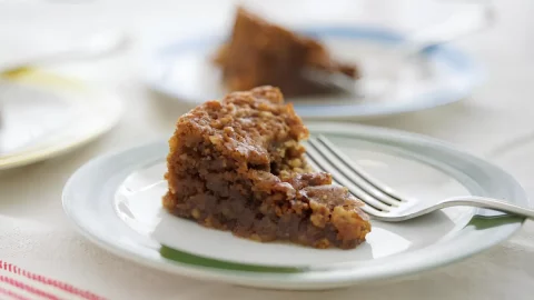 Um prato com uma fatia de bolo de nozes.