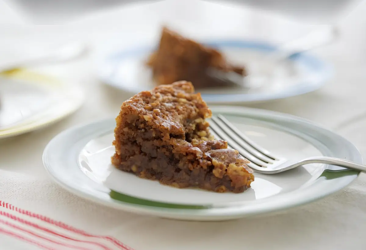 um prato com uma fatia de bolo de nozes.