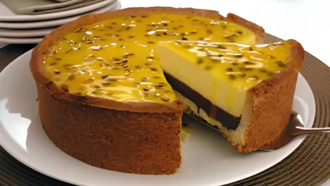 Uma torta de maracujá com chocolate em cima de uma mesa pronto para ser servido.