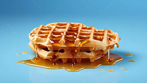 Um prato com waffle com calda de caramelo pronto para ser servido.