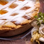 Uma pastiera napolinata tradicional em uma mesa preparada para o natal.