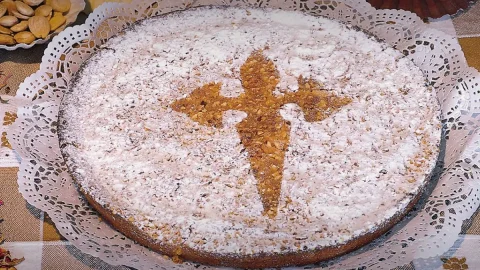 Uma torta de Santiago em uma mesa pronta para ser servida.